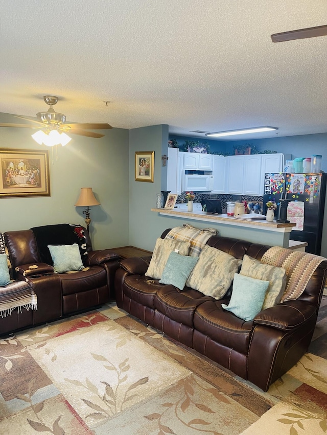 living room featuring a textured ceiling and ceiling fan