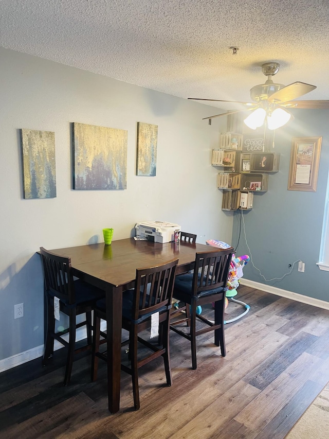 dining space with ceiling fan, wood-type flooring, and a textured ceiling