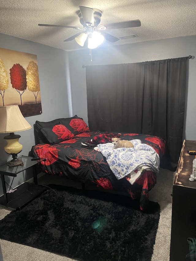 bedroom featuring ceiling fan, carpet, and a textured ceiling