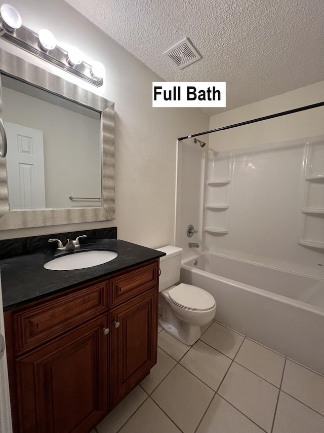 full bathroom featuring tile patterned flooring, washtub / shower combination, toilet, vanity, and a textured ceiling