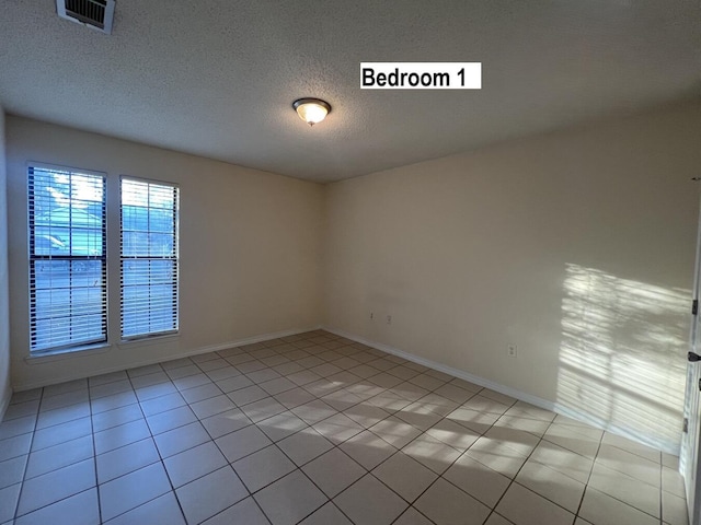 tiled spare room with a textured ceiling