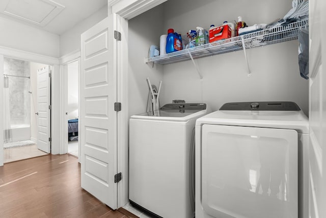 laundry room with washing machine and dryer and hardwood / wood-style floors