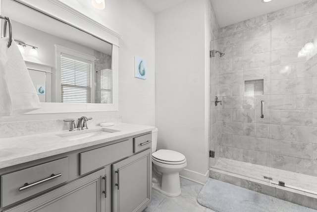 bathroom featuring toilet, a shower with shower door, and vanity