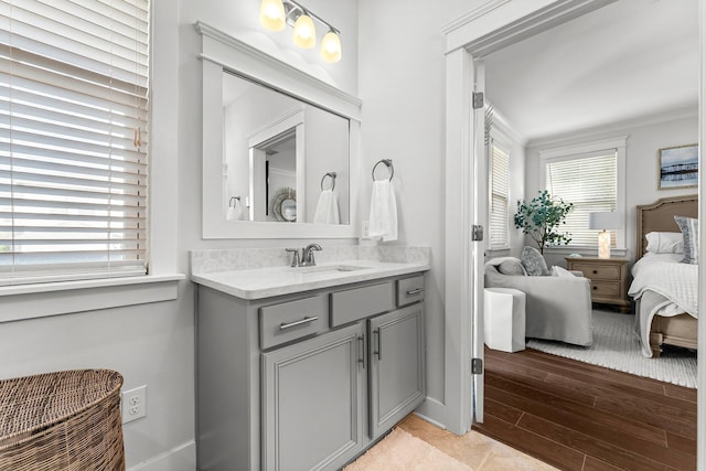 bathroom with hardwood / wood-style floors, vanity, and ornamental molding