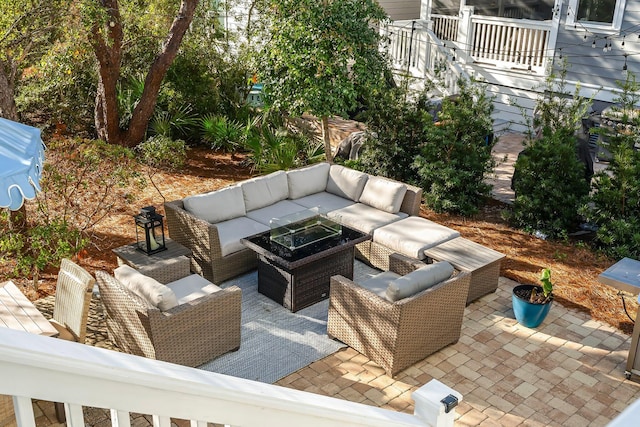 view of patio with an outdoor living space with a fire pit