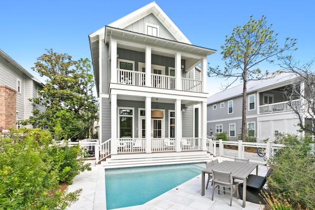 rear view of house featuring a balcony and a patio area