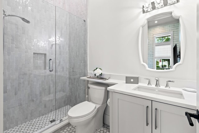 bathroom featuring toilet, tile patterned flooring, walk in shower, and vanity