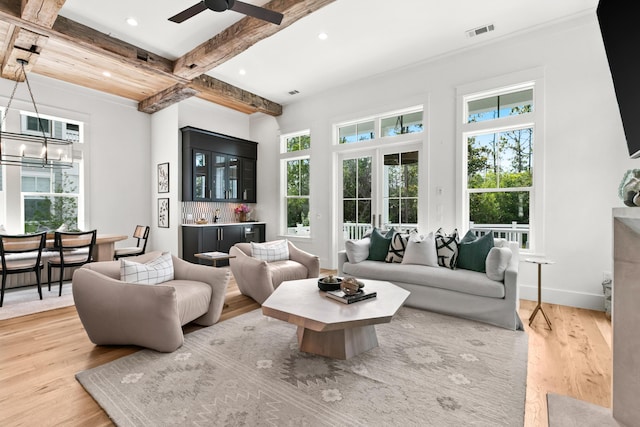 living room with bar, french doors, hardwood / wood-style flooring, beam ceiling, and ceiling fan with notable chandelier