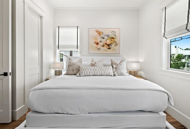 bedroom featuring a closet, crown molding, and wood-type flooring