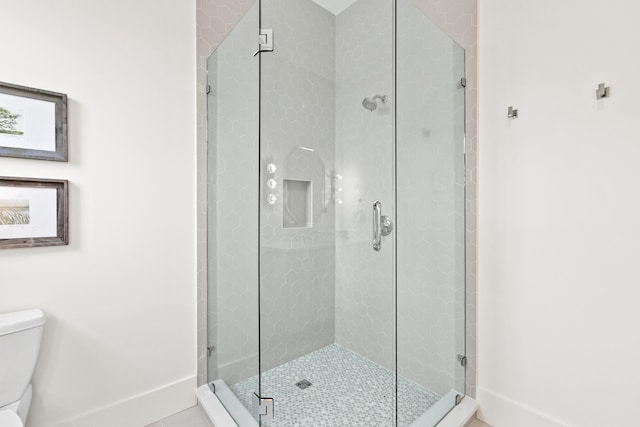 bathroom with tile patterned flooring, a shower with shower door, and toilet