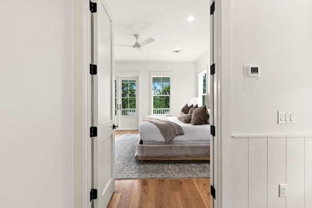 bedroom with ornamental molding, ceiling fan, and light hardwood / wood-style flooring