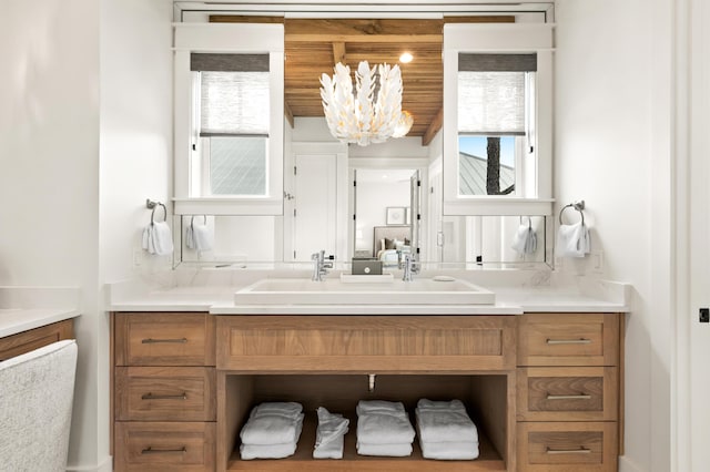 bathroom with wood ceiling, a chandelier, and vanity