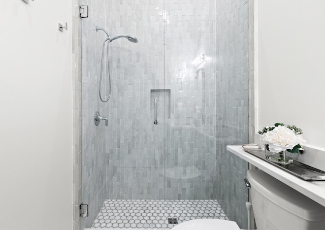 bathroom featuring toilet and a shower with shower door