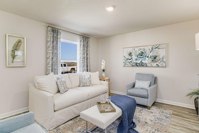 living room with a textured ceiling and light wood-type flooring