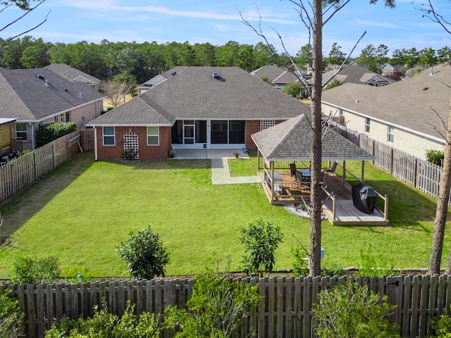 back of house featuring a deck, a gazebo, and a lawn