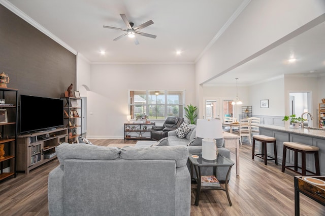 living room with ceiling fan, wood-type flooring, and crown molding