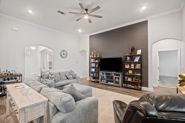 living room with ceiling fan, light hardwood / wood-style flooring, and crown molding