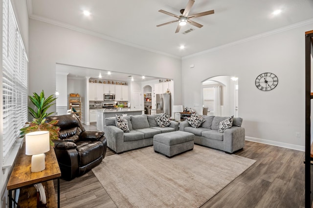 living room with ceiling fan, ornamental molding, and light hardwood / wood-style floors