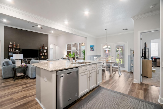 kitchen with pendant lighting, white cabinets, an island with sink, sink, and stainless steel dishwasher