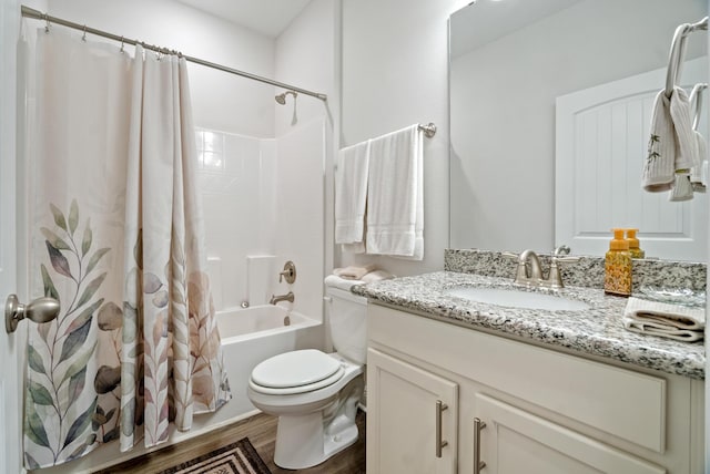 full bathroom featuring toilet, vanity, hardwood / wood-style flooring, and shower / bathtub combination with curtain