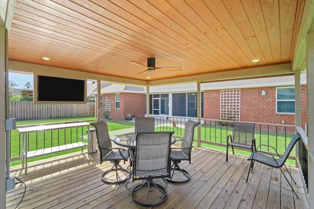 wooden terrace featuring ceiling fan and a yard