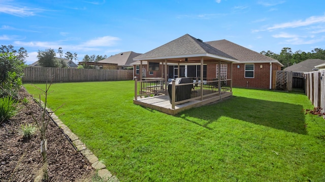 back of property featuring ceiling fan and a yard