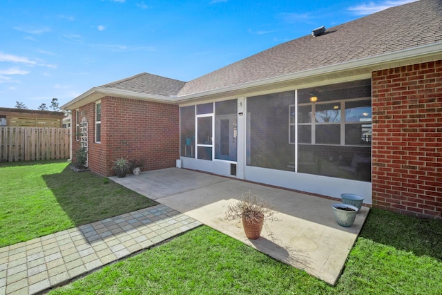 rear view of property with a patio area, a yard, and a sunroom