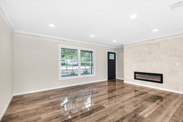 unfurnished living room with a tile fireplace, hardwood / wood-style floors, and crown molding