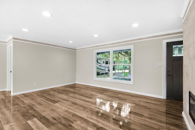 unfurnished living room featuring hardwood / wood-style floors and crown molding