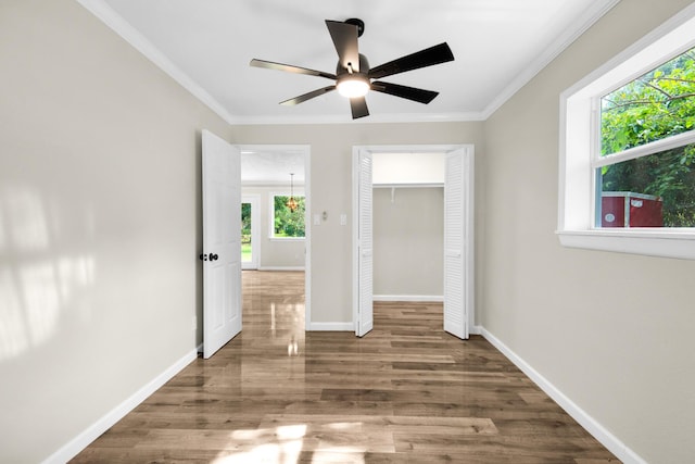 unfurnished bedroom with ceiling fan, ornamental molding, a closet, and hardwood / wood-style flooring