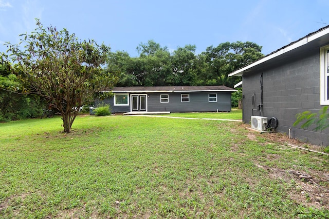 back of house featuring a lawn and ac unit