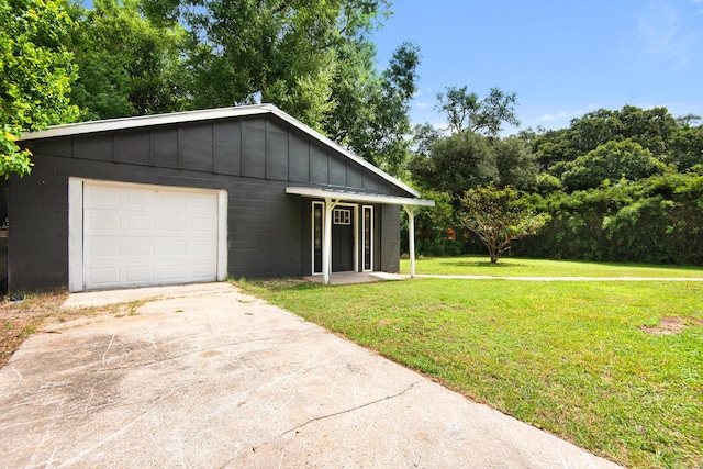 view of front of property with a front lawn, a garage, and an outbuilding