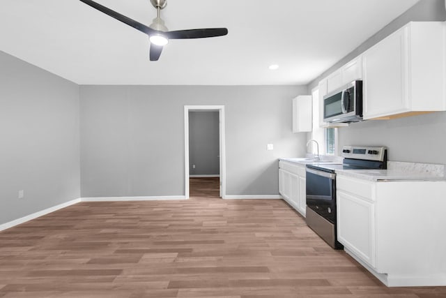 kitchen featuring light hardwood / wood-style flooring, stainless steel appliances, white cabinets, ceiling fan, and sink