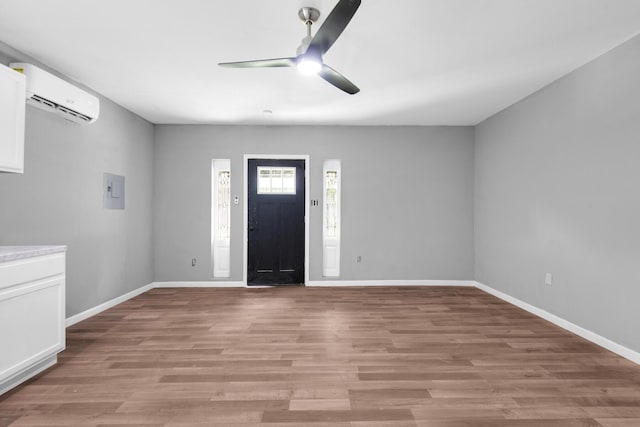 entryway featuring electric panel, a wall mounted AC, ceiling fan, and light hardwood / wood-style floors