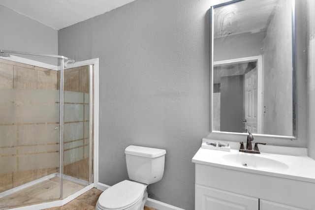 bathroom featuring toilet, tile patterned floors, a shower with shower door, and vanity