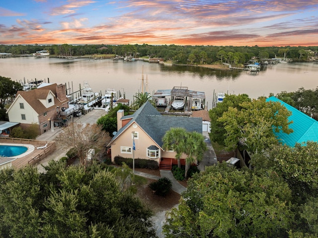 aerial view at dusk featuring a water view