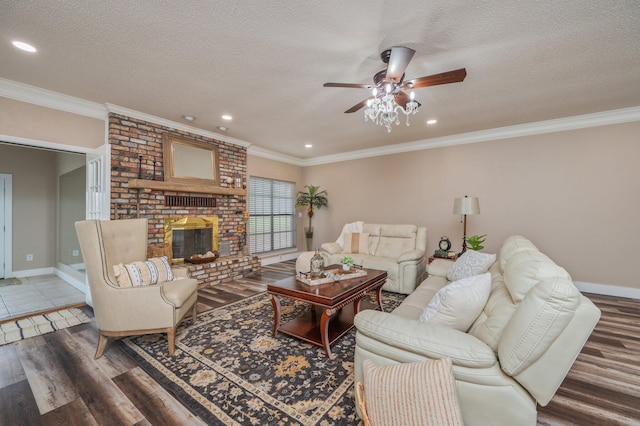 living room featuring crown molding, a brick fireplace, and a textured ceiling