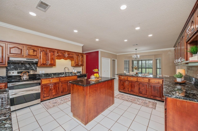 kitchen with light tile patterned floors, sink, pendant lighting, a kitchen island, and stainless steel appliances