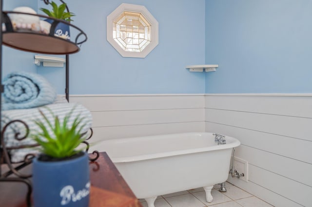 bathroom featuring tile patterned floors, wood walls, and a bath