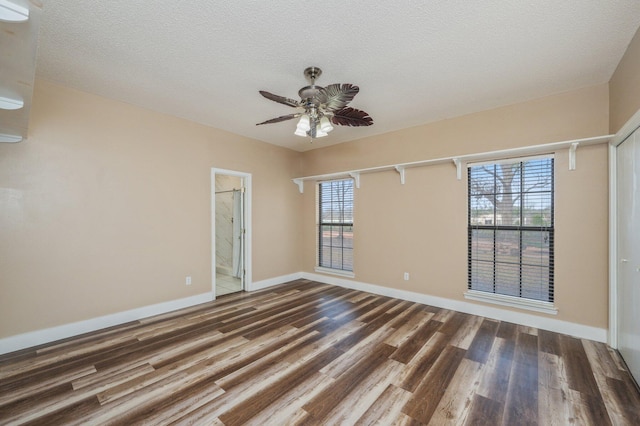 empty room featuring ceiling fan, a textured ceiling, and hardwood / wood-style floors