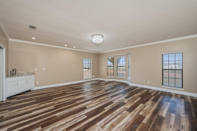 unfurnished living room with a textured ceiling, dark hardwood / wood-style floors, and ornamental molding