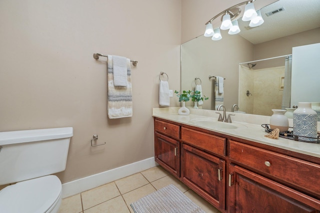 bathroom with toilet, vanity, tile patterned flooring, and walk in shower