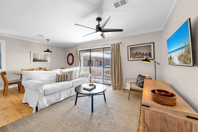 living room with crown molding, hardwood / wood-style floors, and ceiling fan