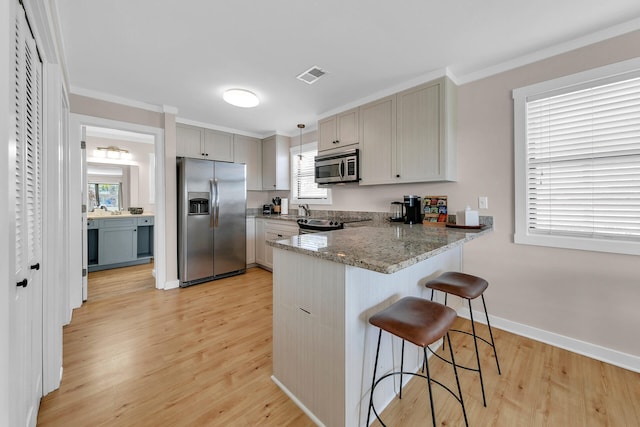 kitchen with stainless steel appliances, decorative light fixtures, light hardwood / wood-style flooring, and gray cabinetry