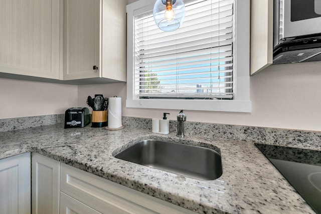 kitchen with light stone countertops and sink