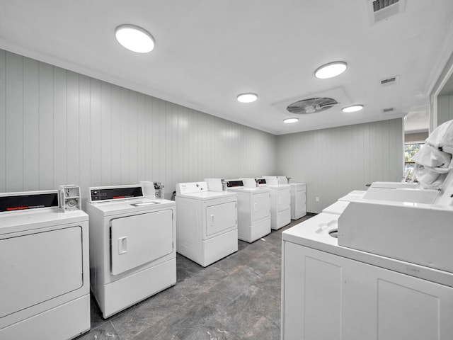 washroom featuring washer and dryer and wood walls