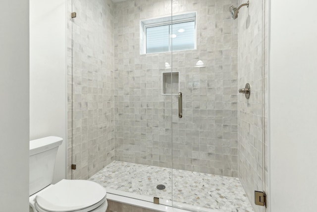 bathroom with an enclosed shower and toilet