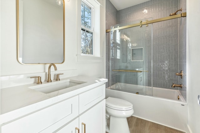 full bathroom with vanity, toilet, combined bath / shower with glass door, and hardwood / wood-style floors