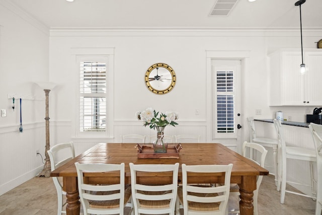 tiled dining room featuring ornamental molding