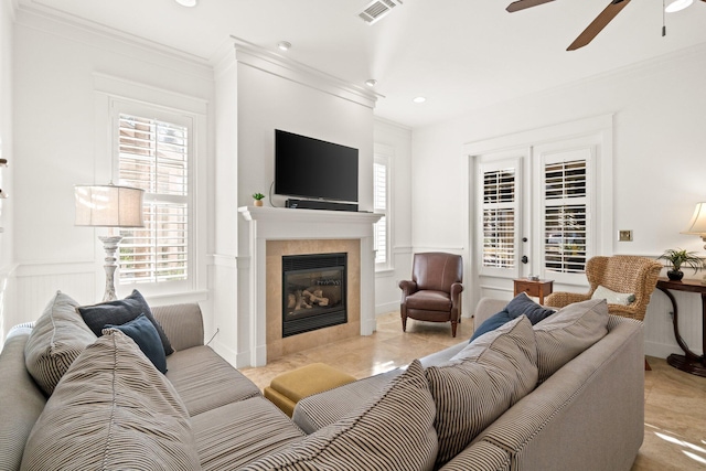 living room featuring ceiling fan, a fireplace, and crown molding